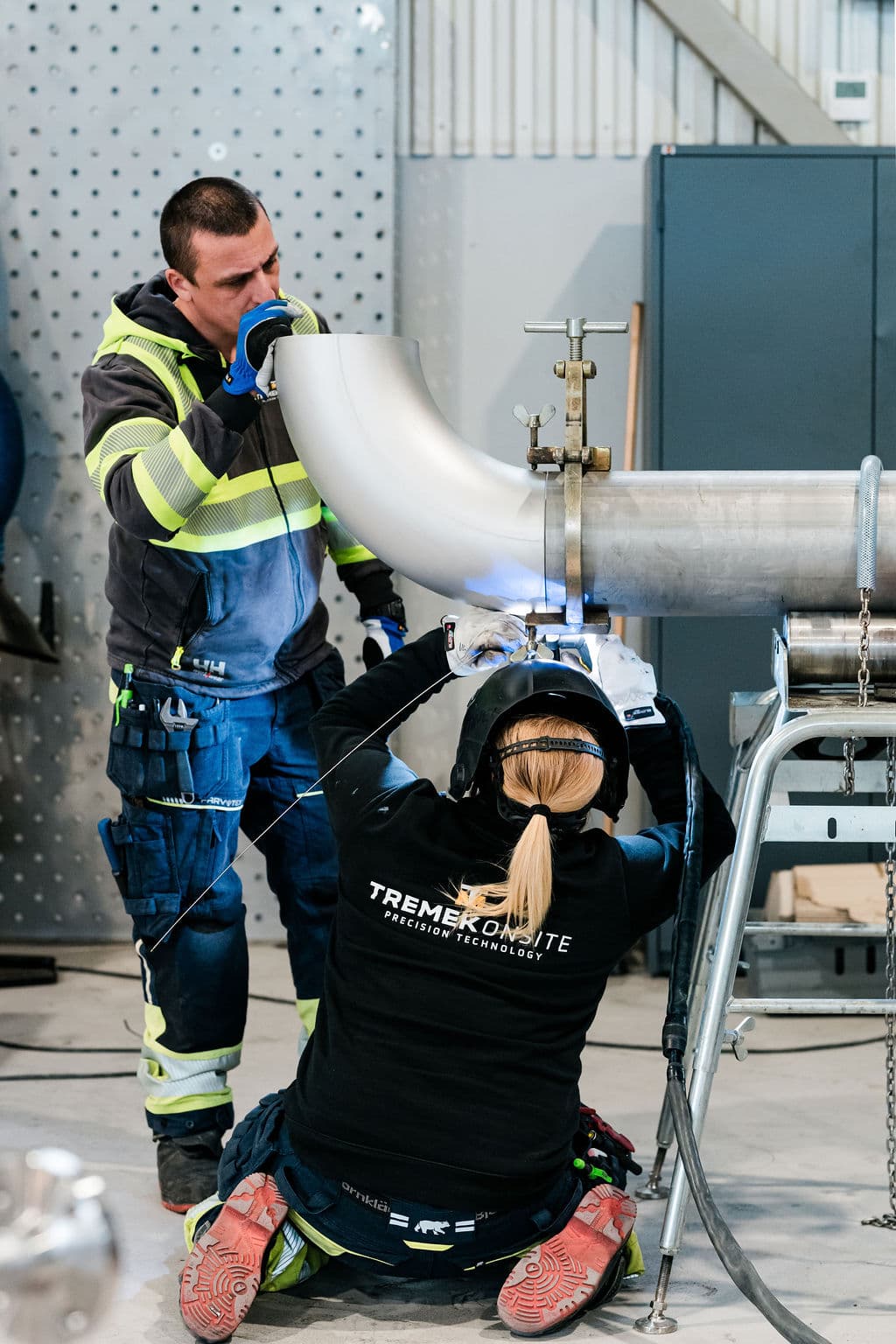 Två medarbetare på Tremek Onsite monterar och svetsar en rörböj